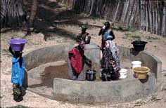 Mujeres en la fuente recogiendo agua